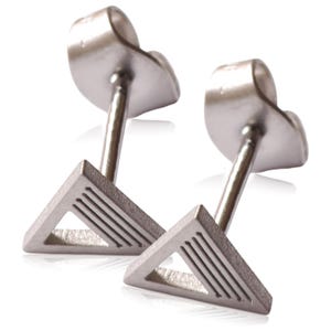 May include: A pair of silver triangle stud earrings with a textured design. The earrings have a post and butterfly backing.