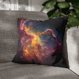 Op de afbeelding: Een zwart kussen met een kleurrijk nevelpatroon. De nevel is een mix van oranje, geel, rood en blauwe kleuren. Het kussen is gemaakt van zacht materiaal en is perfect om een ​​touch van ruimte aan je interieur toe te voegen.