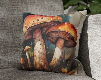 May include: Square cushion with a watercolour painting of mushrooms. The mushrooms have orange and brown caps with white spots and brown stems. The background is a dark blue with white speckles.