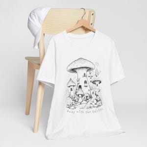 May include: White t-shirt with a black and white illustration of a mushroom house with the text "away with the fairies".