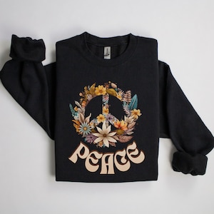May include: Black sweatshirt with a peace sign surrounded by flowers and the word "peace" in a retro font.