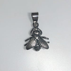 May include: A silver bee pendant with detailed wings and body. The pendant has a loop at the top for a chain. The bee's wings are spread, and the body has striped detailing. The pendant is likely made of metal.