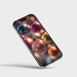 May include: A smartphone displays a festive image of colorful Christmas ornaments. The ornaments are in shades of red, purple, blue, and gold, with a blurred background. The phone has a silver frame and a black screen.