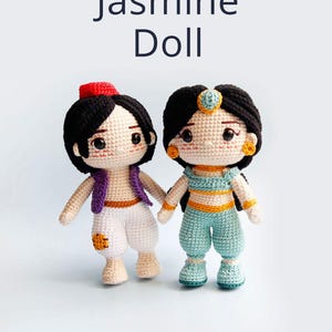 May include: Crocheted amigurumi dolls of Jasmine and Aladdin from the Disney movie Aladdin. Jasmine is wearing a blue and gold outfit with a blue headband. Aladdin is wearing a purple vest, white pants, and a red hat.