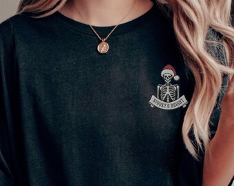 May include: Black oversized t-shirt with a skeleton wearing a Santa hat and a banner that reads "Spooky & Bright".
