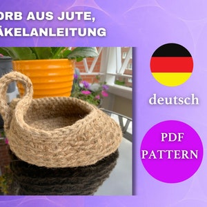 May include: A crocheted jute basket with a handle. The basket is brown and has a natural, rustic look. The image also includes the text "KORB AUS JUTE, HÄKELANLEITUNG" in German, which translates to "Basket made of jute, crochet instructions".