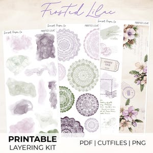 May include: A printable layering kit titled "Frosted Lilac" featuring watercolor elements, mandala designs, and floral illustrations. The kit includes PDF, cut files, and PNG formats. The color palette includes shades of purple, green, and white.