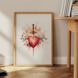 Pode incluir: Uma pintura em aquarela de um cora&ccedil;&atilde;o vermelho atravessado por uma espada, rodeado de rosas brancas e uma explos&atilde;o de luz.