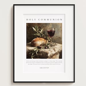 May include: Framed art print featuring a still life with a loaf of bread, olives, and a glass of red wine. The words "HOLY COMMUNION" are at the top. The print includes a Bible verse from Luke 22:19-20.