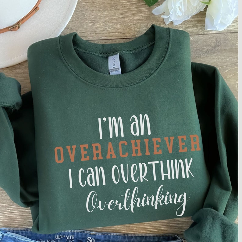 May include: A dark green sweatshirt with the text "I'm an overachiever I can overthink overthinking" in white and orange lettering.