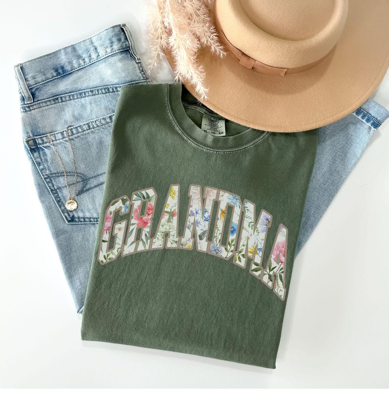 May include: A green t-shirt with a floral print design that spells out "Grandma".