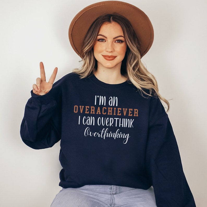 May include: A navy blue sweatshirt with the text "I'm an overachiever I can overthink overthinking" in white and brown lettering.