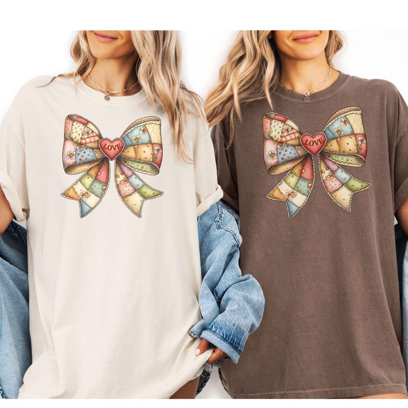 May include: Two t-shirts, one cream and one brown, each featuring a large bow design. The bow is made of patchwork squares in pastel colors, with a red heart in the center that reads "LOVE". The shirts have short sleeves and a relaxed fit.
