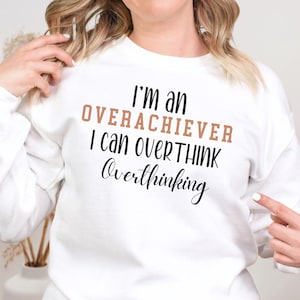 May include: White sweatshirt with the text "I'm an overachiever I can overthink overthinking" in black and brown lettering.