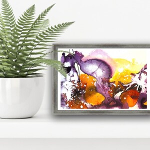 May include: Abstract painting in a gray frame with purple, yellow, and white colors. The painting has a fluid, organic style.