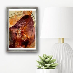 May include: Abstract watercolor painting in shades of brown, orange, and purple with black lines. The painting is framed in a gray frame.
