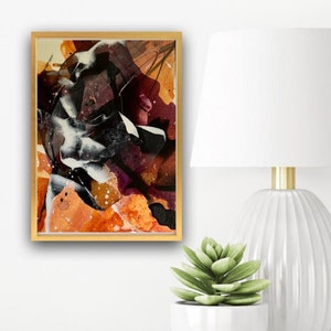 May include: Abstract painting in a gold frame with shades of brown, orange, white, and black. The painting has a textured, layered look.