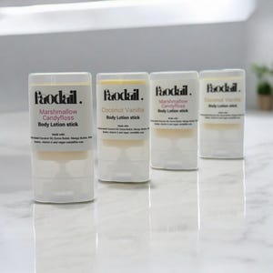 May include: Four clear body lotion sticks with white labels and the brand name "Paodail." The labels read "Marshmallow Candyfloss" and "Coconut Vanilla." The lotion sticks are on a white surface.