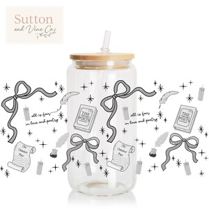 May include: A clear glass tumbler with a bamboo lid and straw, decorated with gray bows, candles, scrolls, and the text "all is fair in love and poetry." The tumbler also features the text "The Tortured Poets Department."