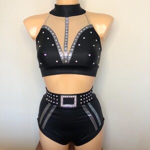 Puede incluir: Traje de baile negro con un top halter y pantalones cortos. El top tiene un panel de malla transparente y est&aacute; decorado con diamantes de imitaci&oacute;n plateados. Los pantalones cortos tienen un cintur&oacute;n de diamantes de imitaci&oacute;n plateados con una hebilla cuadrada.