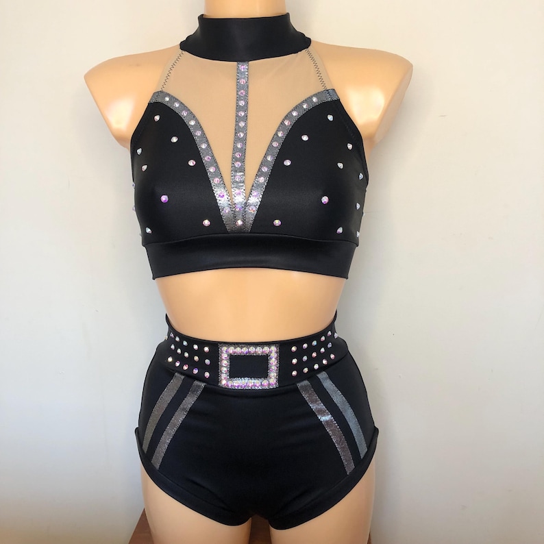 Puede incluir: Traje de baile negro con un top halter y pantalones cortos. El top tiene un panel de malla transparente y est&aacute; decorado con diamantes de imitaci&oacute;n plateados. Los pantalones cortos tienen un cintur&oacute;n de diamantes de imitaci&oacute;n plateados con una hebilla cuadrada.