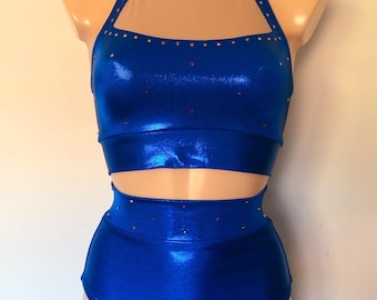 May include: A blue metallic dance costume with a halter top and high-waisted bottoms. The top has a sheer mesh panel and both pieces are embellished with rhinestones.