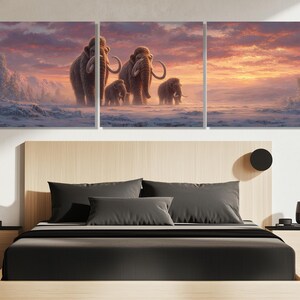 May include: A triptych canvas print depicting a family of woolly mammoths walking across a snowy landscape. The artwork features a warm sunset sky with shades of orange, pink, and purple. The mammoths are brown with large tusks.