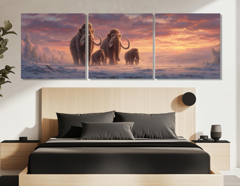 May include: A triptych canvas print depicting a family of woolly mammoths walking across a snowy landscape. The artwork features a warm sunset sky with shades of orange, pink, and purple. The mammoths are brown with large tusks.