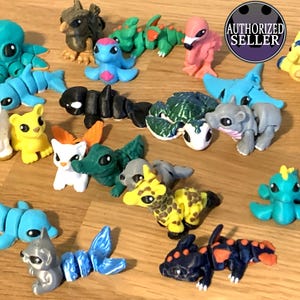 May include: A selection of brightly coloured, handcrafted figurines of various creatures, including an octopus, zebra, unicorn, and dragon-like figures. The figurines are in shades of blue, yellow, green, black, and pink, on a wooden surface.