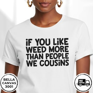 May include: White t-shirt with the text "IF YOU LIKE WEED MORE THAN PEOPLE WE COUSINS" in black block letters. The shirt is a Bella Canvas 3001 model.