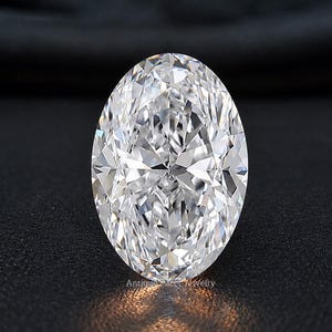 May include: A clear, oval-cut gemstone with multiple facets that reflect light, creating a brilliant sparkle. The stone is positioned upright and features the faint text Antique Racer Jewelry at its base, showcasing a high level of clarity.