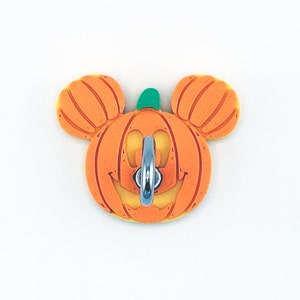May include: Orange and green Halloween pumpkin shaped wall hook with a silver ring.