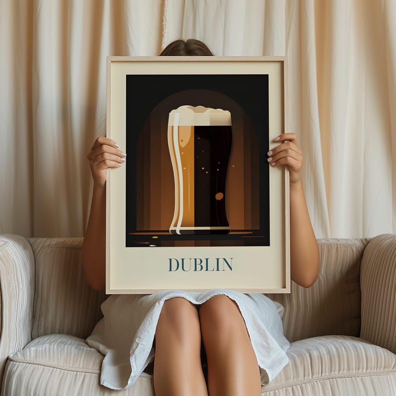 A person is sitting on a couch holding a framed picture of a beer mug with the word "DUBLIN" written on it.