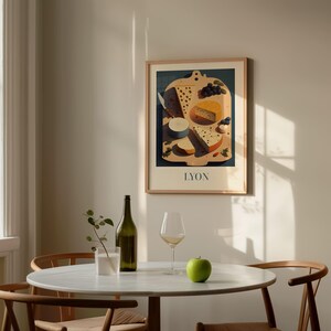a dining table with a white tablecloth, a green bottle, a wine glass, and a green apple. Above the table, there is a framed picture of cheese and grapes.