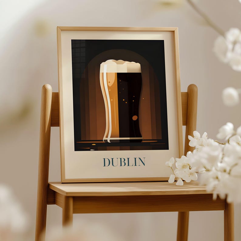 A framed poster of a glass of beer is displayed on a wooden chair, with white flowers in the background.