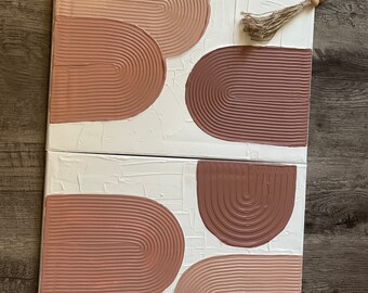 May include: Two canvases with a textured white background and abstract shapes in shades of pink and brown. The shapes are arches with a raised, textured surface.