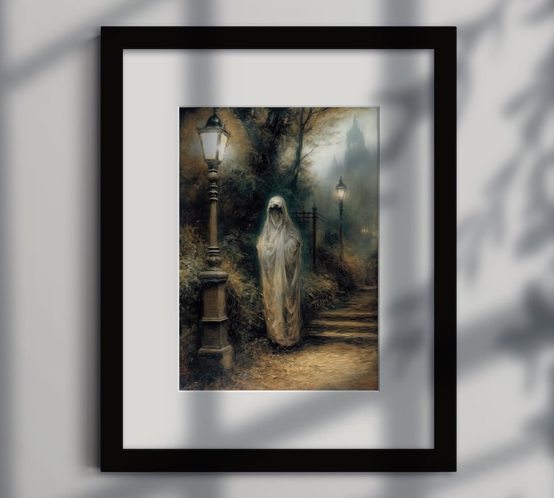 Op de afbeelding: Een schilderij van een spookachtige figuur in een witte gewaden met kap, die op een pad in een bos staat. De figuur loopt naar een lantaarnpaal. Het schilderij is omlijst in zwart.