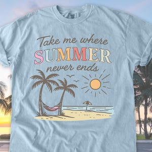 May include: Light blue t-shirt with the text "Take me where SUMMER never ends" in colorful letters. The graphic features palm trees, a hammock, a sun, and a beach scene. The shirt is made of a soft material.
