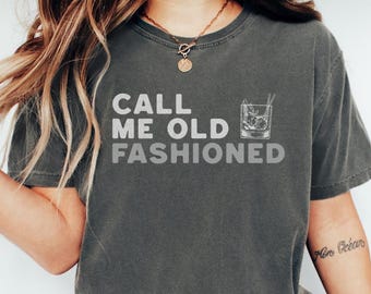 May include: A dark gray t-shirt with the text "Call me old fashioned" and a drawing of an old fashioned cocktail glass.
