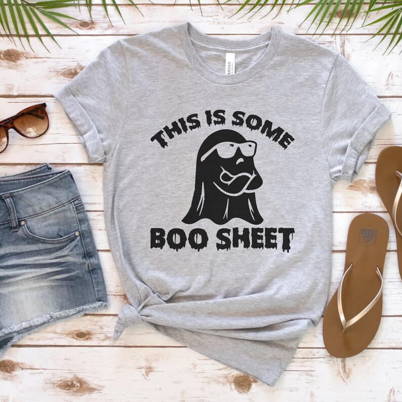 May include: A gray t-shirt with a black ghost wearing sunglasses and the text "This is some boo sheet".