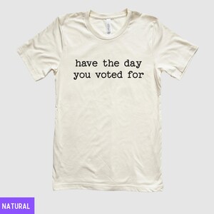 May include: A white t-shirt with the text "have the day you voted for" printed in black.