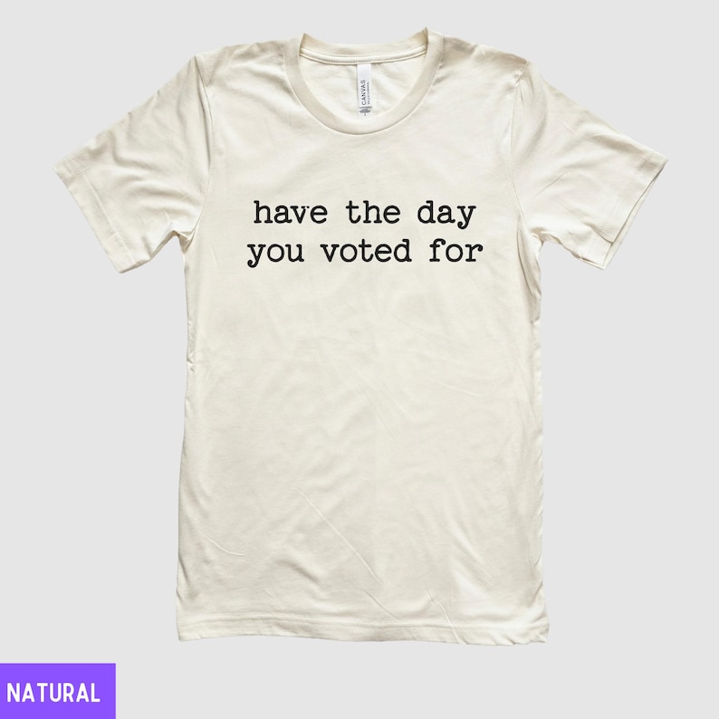 May include: A white t-shirt with the text "have the day you voted for" printed in black.