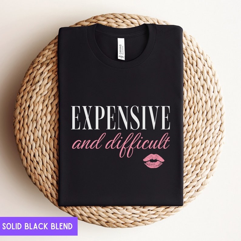 May include: Black t-shirt with white text that reads "EXPENSIVE and difficult" with a pink lip print below the text.