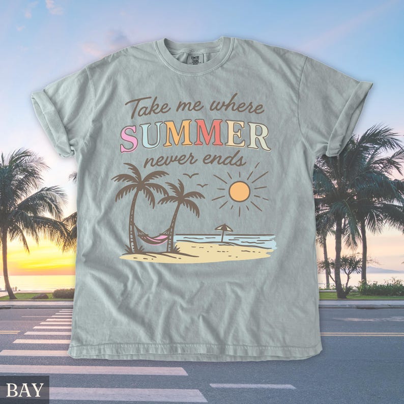 May include: A light blue t-shirt with the text "Take me where SUMMER never ends." The graphic features a beach scene with palm trees, a hammock, and a sun. The shirt has rolled-up sleeves.