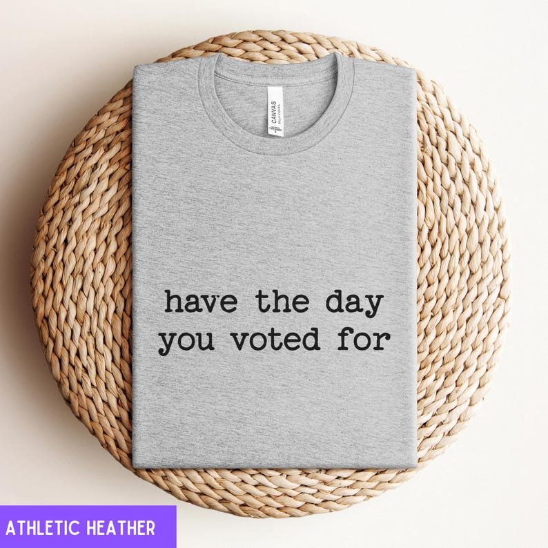 May include: A heather grey t-shirt with the text "have the day you voted for" printed in black.