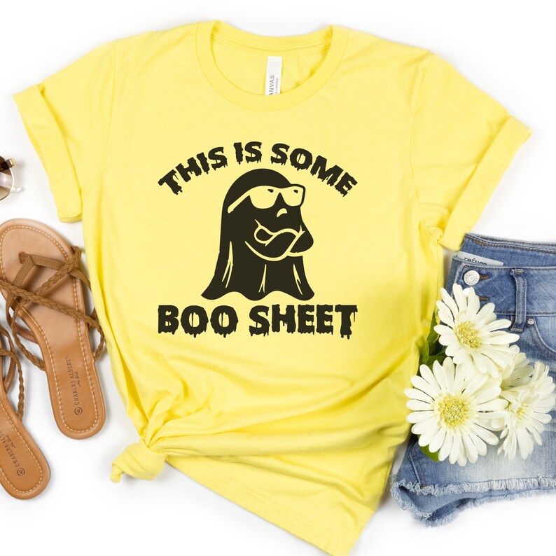 May include: Yellow t-shirt with a black ghost wearing sunglasses and the text "This is some boo sheet".