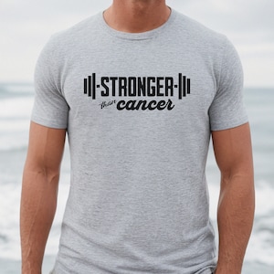 May include: A gray t-shirt with the text "STRONGER than cancer" and a barbell graphic.