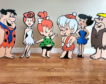 Puede incluir: Un conjunto de seis recortes de personajes de dibujos animados que representan a la familia Picapiedra. Los personajes son Pedro Picapiedra, Vilma Picapiedra, Pebbles Picapiedra, Pablo Mármol, Betty Mármol y Bamm-Bamm Mármol. Los recortes están impresos en cartón y están listos para ser utilizados para una fiesta o evento.
