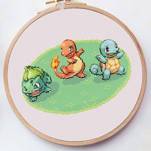 May include: Cross stitch pattern featuring three Pokemon characters: Bulbasaur, Charmander, and Squirtle. The characters are on a green background.