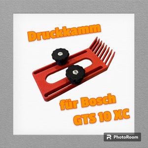 Pode incluir: Ferramenta de plástico vermelha com o texto "Druckkamm für Bosch GTS 10 XC" em laranja. A ferramenta tem duas botões pretos e uma borda em forma de pente.